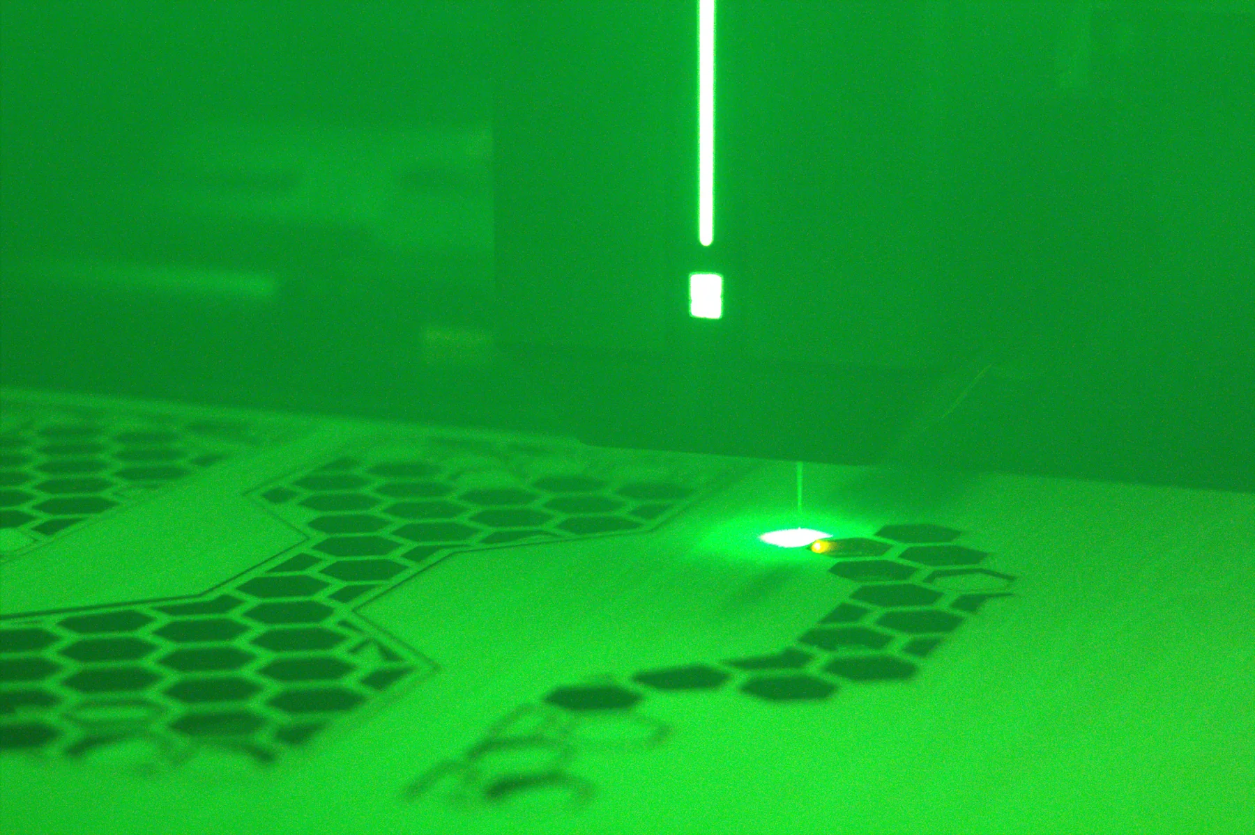 Laser processing a patterned sheet inside the fabrication enclosure